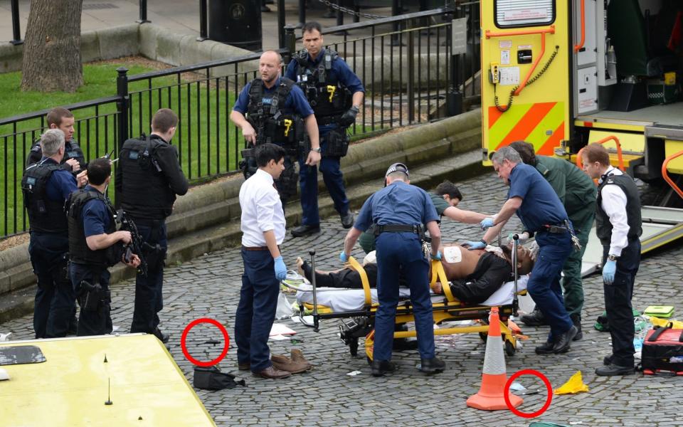 The suspected London terror attacker being treated by paramedics, with the knives used in the assault circled. - Credit: PA
