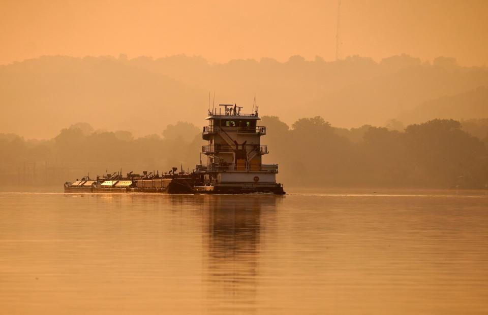 A barge makes its way down the Ohio River around Delhi on Wednesday. The area is under an air quality alert, from the Southwest Ohio Air Quality Agency. The agency reccomends are urging people to fill their gas tank after 6 p.m. and avoid driving and using gas-powered equipment.