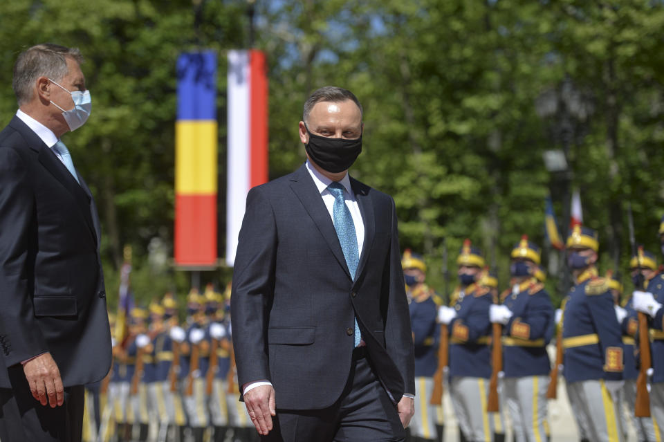 Polish President Andrzej Duda, right, reviews the honor guard with Romanian President Klaus Iohannis during the welcoming ceremony at the Cotroceni presidential palace in Bucharest, Romania, Monday, May 10, 2021. (AP Photo/Alexandru Dobre)