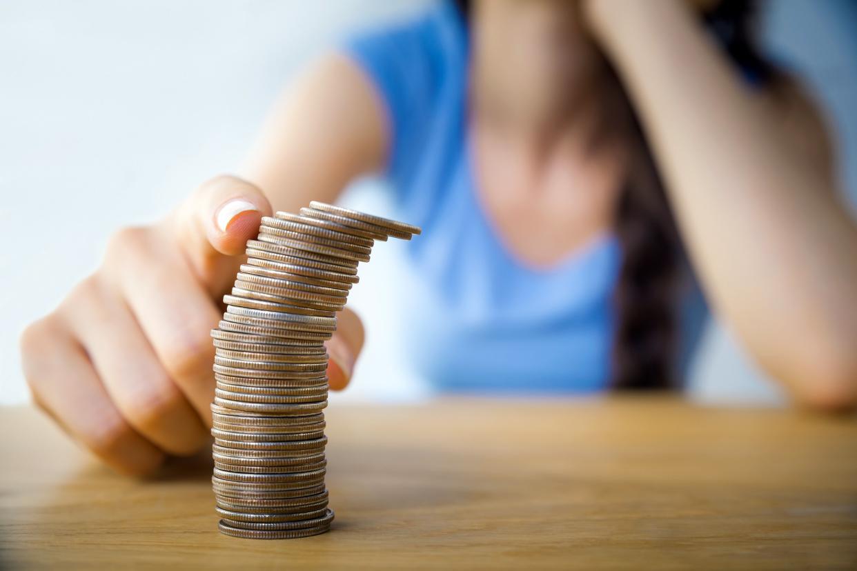 Closeup of stack of coins with woman in the background