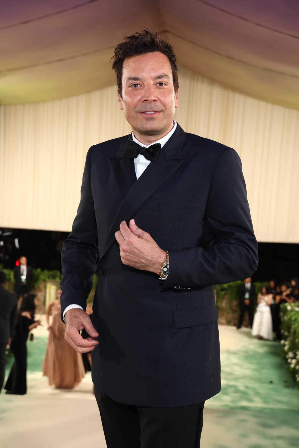 Jimmy Fallon standing in a suit with a bow tie at an event