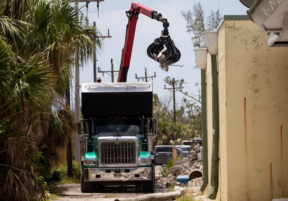 A truck is filled with debris from the demolition of the shops by Bailey's General Store on Friday, July 21, 2023, on Sanibel Island. The demolition will eventually include the building housing Bailey's.