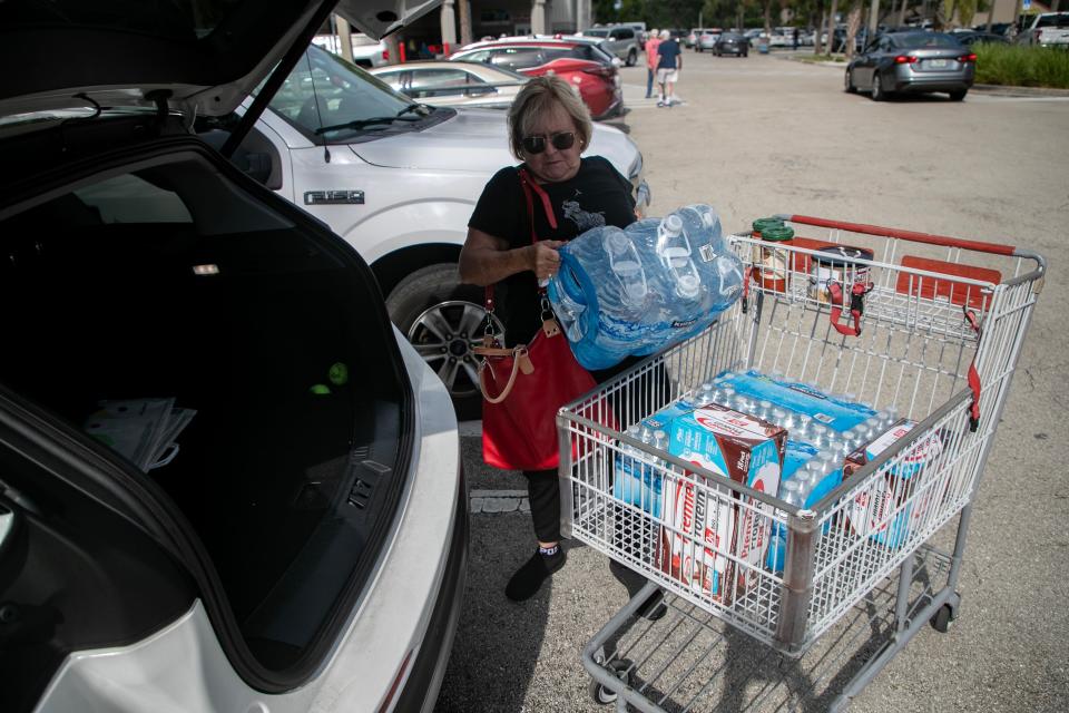 June Sandoe loads water into her car at Costco in Fort Myers on Monday, Aug. 28, 2023.