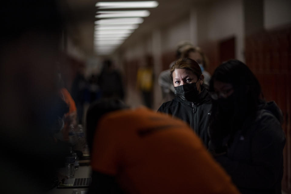 A woman waits in line at a vaccination clinic in Central Falls, R.I., Saturday Feb. 6, 2021. Nearly a third of adults in the city have received at least one dose of vaccine, according to state data. Health officials say the city of about 20,000 has seen a marked drop in COVID-19 cases as a result. (AP Photo/David Goldman)