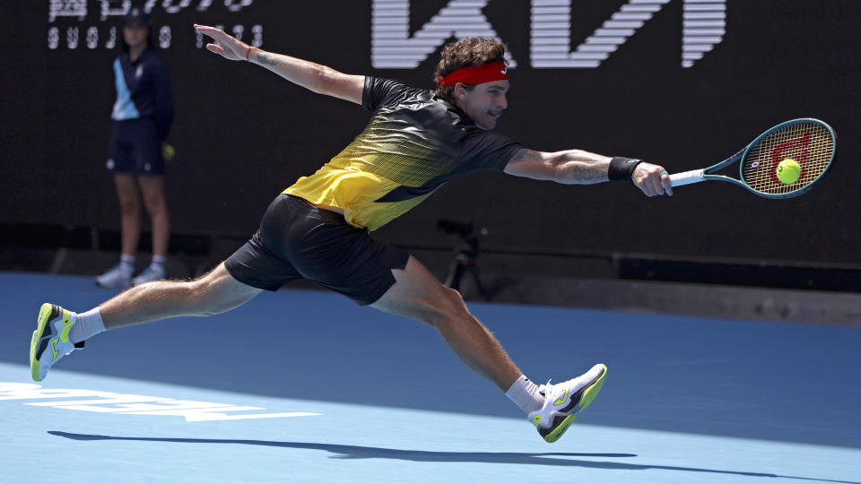 Thiago Seyboth Wild of Brazil plays a backhand return to Andrey Rublev of Russia during their first round match at the Australian Open tennis championships at Melbourne Park, Melbourne, Australia, Sunday, Jan. 14, 2024. (AP Photo/Asanka Brendon Ratnayake)