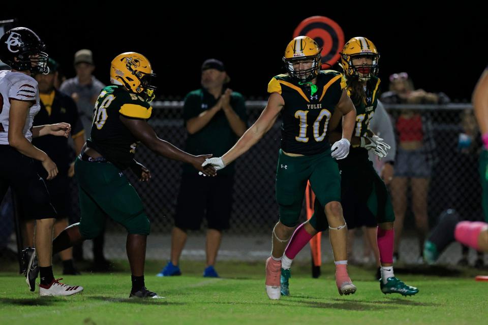Yulee's Kendell Heyward (56) congratulates teammate Rylan Hale (10) for his two point conversion during the third quarter of a regular season football matchup Friday, Oct. 13, 2022 at Yulee High School in Yulee. The Baker County Wildcats edged the Yulee Hornets 31-30.