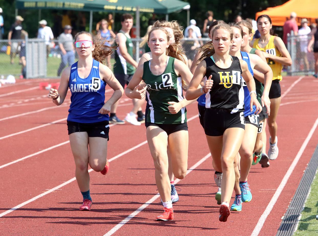 U-32's Ginger Long (left), Rice's Elizabeth Cunningham (center) and Harwood's Charlie Flint battle down the backstretch of the girls 1500 meter race on Friday afternoon at BHS in the 2023 D2 track and field state championships.