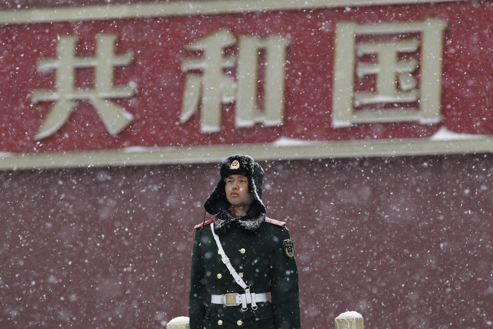 In this Tuesday, Feb. 12, 2019, file photo, a paramilitary policeman stands guard outside the Tiananmen Gate as snow falls in Beijing. China's capital is mostly dry in the winter but a storm system brought snow to the city on Tuesday morning. (AP Photo/Andy Wong, File)