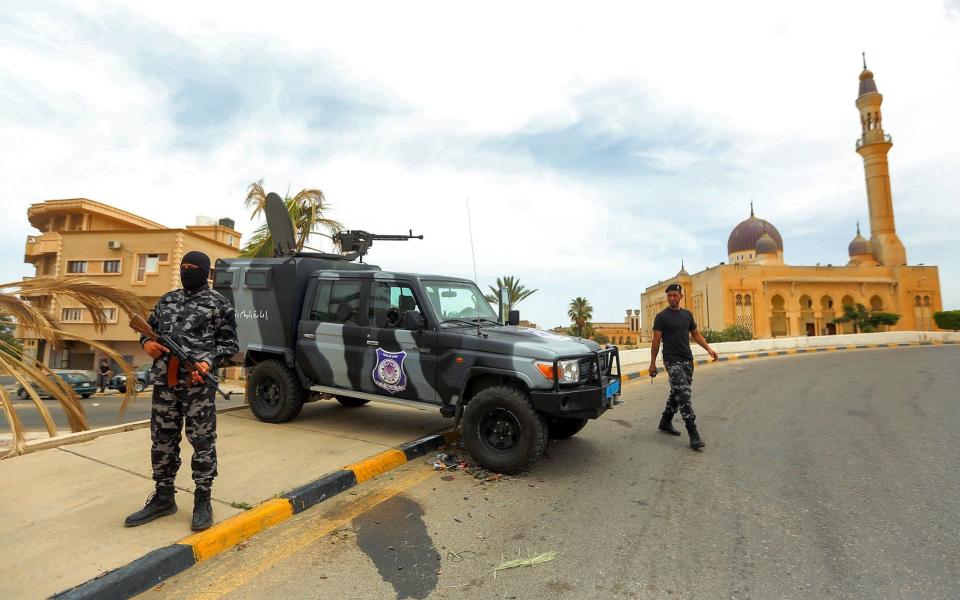 Members of security forces affiliated with the Libyan Government of National Accord (GNA)'s Interior Ministry stand at a make-shift checkpoint - AFP