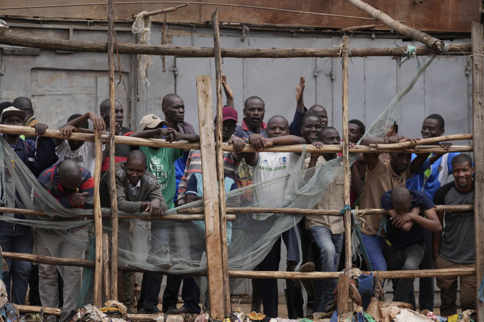 Residents watch as excavators and bulldozers bring down homes in the Mathare area of Nairobi, Kenya, Wednesday, May. 8, 2024. The Kenyan government ordered the evacuation of people from flood-prone areas, resulting in the demolition of houses and the loss of at least one life in the melee caused by the forced evictions. (AP Photo/Brian Inganga)