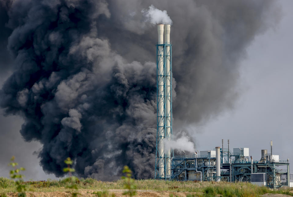 A dark cloud of smoke rises above the Chempark in Leverkusen, Germany, Tuesday, July 27, 2021. After an explosion, fire brigade, rescue forces and police are currently in large-scale operation, the police explained.(Oliver Berg/dpa via AP)