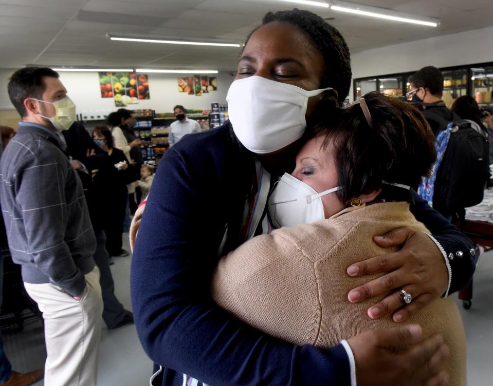 Pastor Heather Boone, founder of Oaks of Righteousness receives a big hug from Monroe Public Schools Superintendent Julie Everly in congratulations of opening The Village Market off Fourth St. in Monroe which opened Friday, March 26, 2021. This is one of several images taken by photographer Tom Hawley as he follows the journey of Pastor Heather Boone.