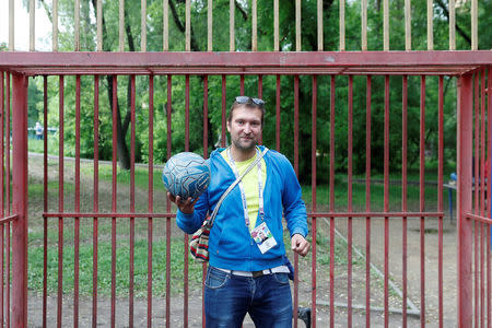 Soccer fan Pavel Cherkas, who was blacklisted by Russian authorities for bad behaviour at a stadium, poses for a picture with his 2018 World Cup fan ID, which was granted to Cherkas and later revoked, during an interview outside Moscow, Russia May 20, 2018. REUTERS/Maxim Shemetov