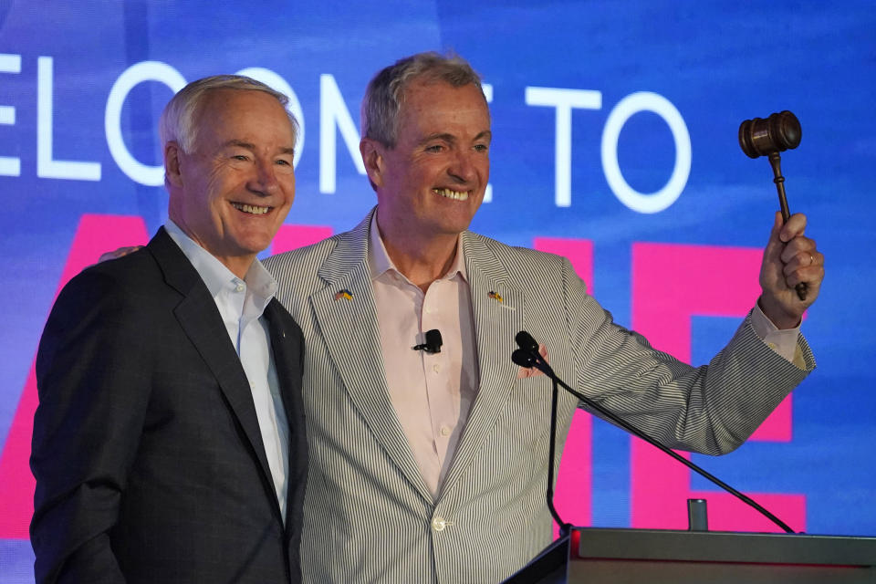 Arkansas Gov. Asa Hutchinson, left, and New Jersey Gov. Phil Murphy acknowledge applause at the National Governors Association summer meeting, Friday, July 15, 2022, in Portland, Maine. (AP Photo/Robert F. Bukaty)