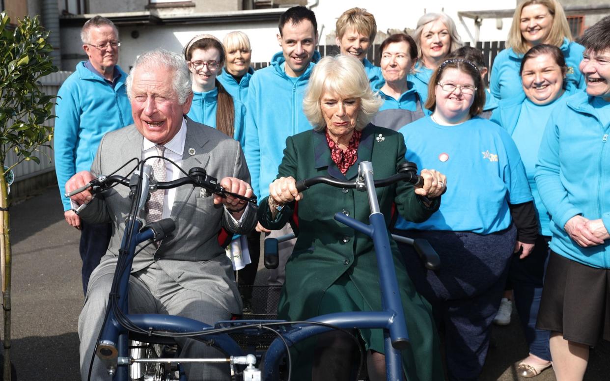 The Prince of Wales and the Duchess of Cornwall hopped aboard a bicycle at the Superstars Cafe in Cookstown - Liam McBurney/PA Wire