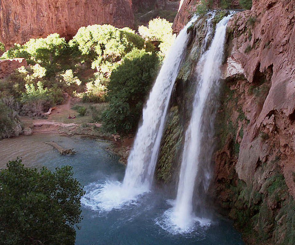 FILE - This 1997 file photo shows one of five waterfalls on Havasu Creek as its waters tumble 210 feet on the Havasupai Tribe's reservation in a southeastern branch of the Grand Canyon near Supai, Ariz. Reservations open up next month for tourists eager to snag a camping spot at the bottom of the Grand Canyon where blue-green waterfalls appear like oases in the desert. (AP Photo/Bob Daugherty, File)