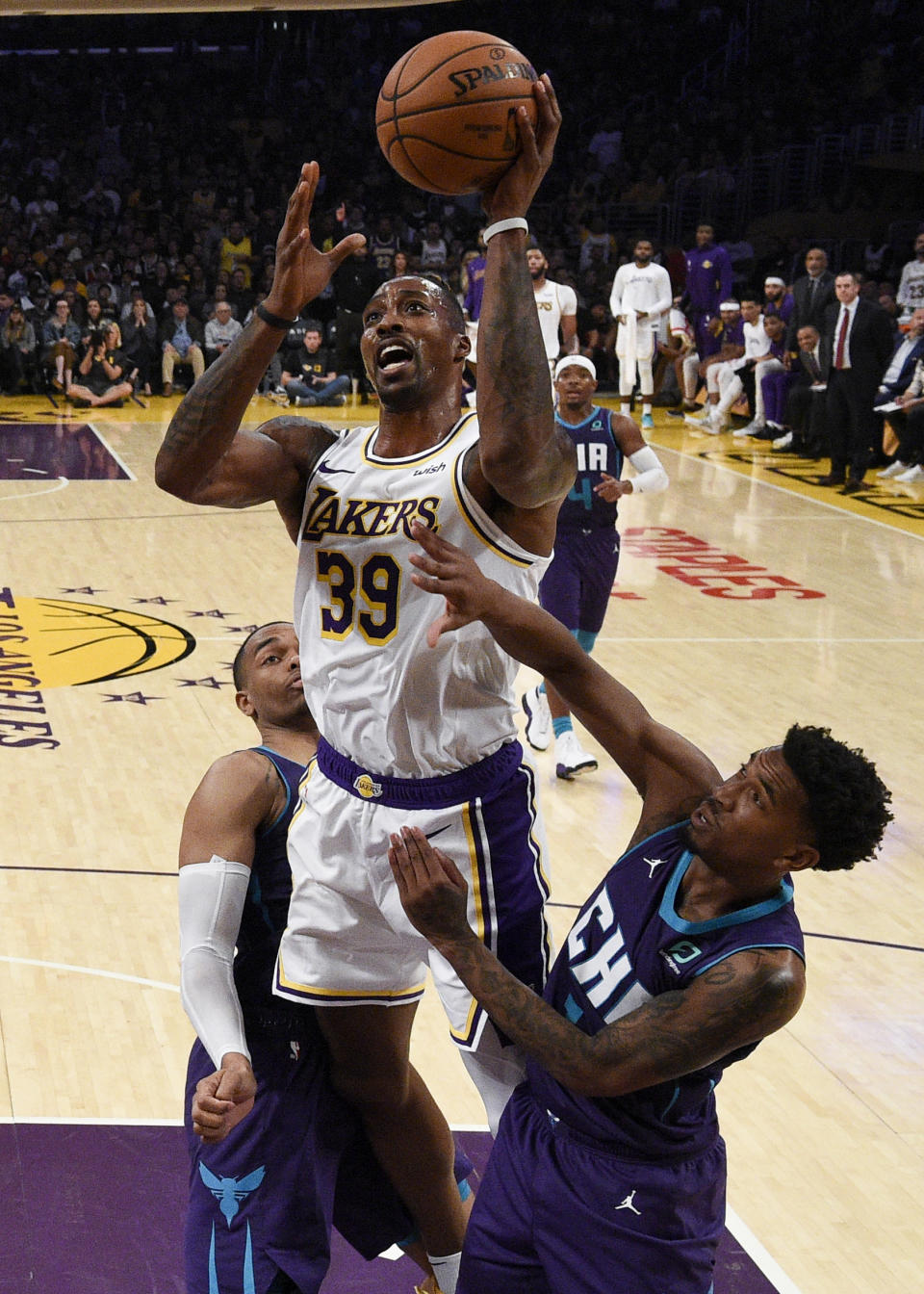 Los Angeles Lakers center Dwight Howard, center, goes up for a shot while Charlotte Hornets guard Malik Monk, right, and PJ Washington defend during the second half of an NBA basketball game in Los Angeles, Sunday, Oct. 27, 2019. The Lakers won 120-101. (AP Photo/Kelvin Kuo)