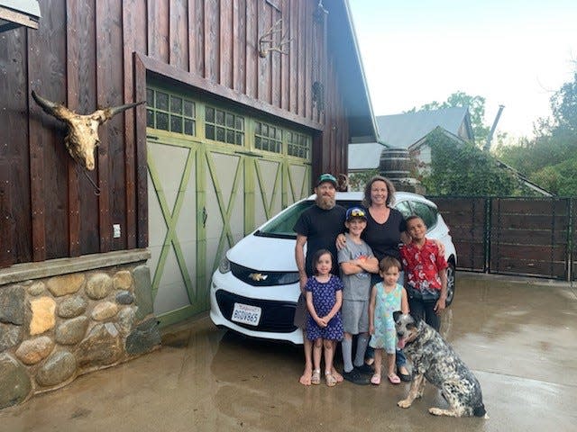 The Gardner family with the 2019 Chevrolet Bolt that GM has agreed to buy back. From left: Nathan Gardner, Tracy Gardner (adults), Lily Gardner, Carver Gardner, Sammy Gardner, Jonathan Gardner and Sky (dog).