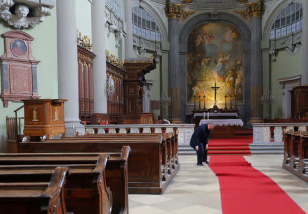 Miklos Beer, the bishop of Vac, adjusts a carpet in the cathedral in Vac, Hungary March 9, 2017. REUTERS/Laszlo Balogh