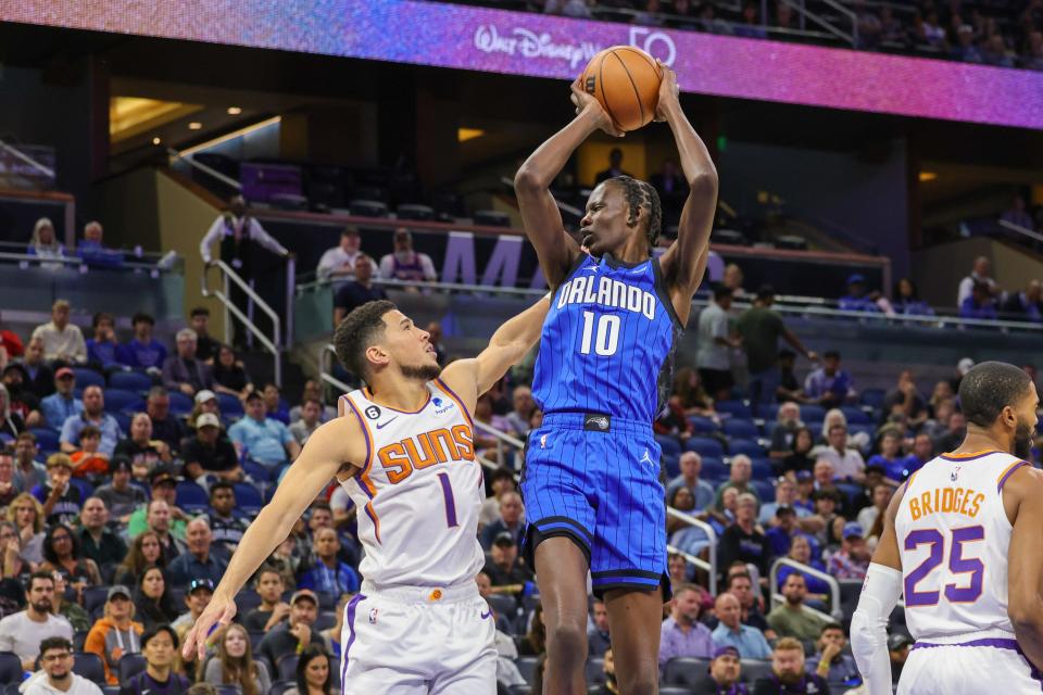 Nov 11, 2022; Orlando, Florida, USA; Orlando Magic center Bol Bol (10) goes to the basket over Phoenix Suns guard Devin Booker (1) during the first quarter at Amway Center. Mandatory Credit: Mike Watters-USA TODAY Sports