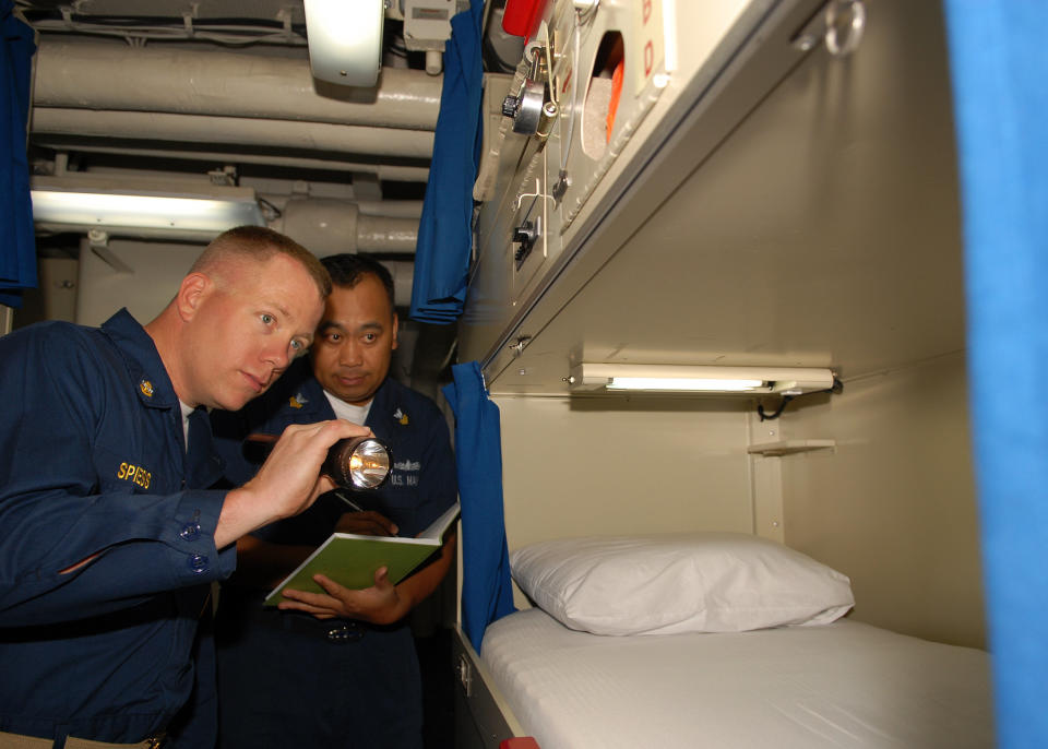 Chief Petty Officer Albert S. Spiess, master-at-arms, left, inspects a berthing space as Petty Officer 1st Class Jun R. Gozon, culinary specialist, berthing petty officer in-charge, logs discrepancies during a messing and berthing inspection aboard the amphibious dock landing ship USS Harpers Ferry. Harpers Ferry is part of the forward-deployed Essex Amphibious Ready Group and is conducting spring patrol to the Western Pacific Ocean.