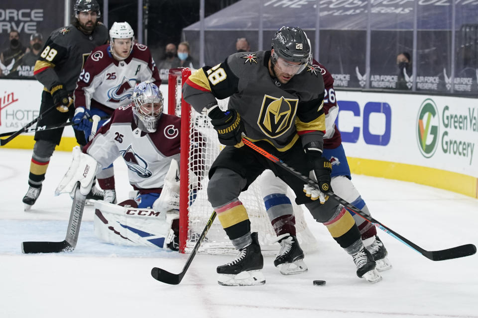 Vegas Golden Knights left wing William Carrier (28) skates around Colorado Avalanche defenseman Jacob MacDonald (26) during the second period of an NHL hockey game Monday, May 10, 2021, in Las Vegas. (AP Photo/John Locher)