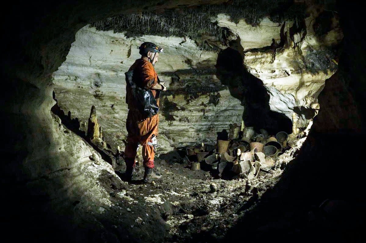 An archaeologist stands next to pre-columbian artifacts in a cave at the Mayan ruins of Chichen Itza (AP)