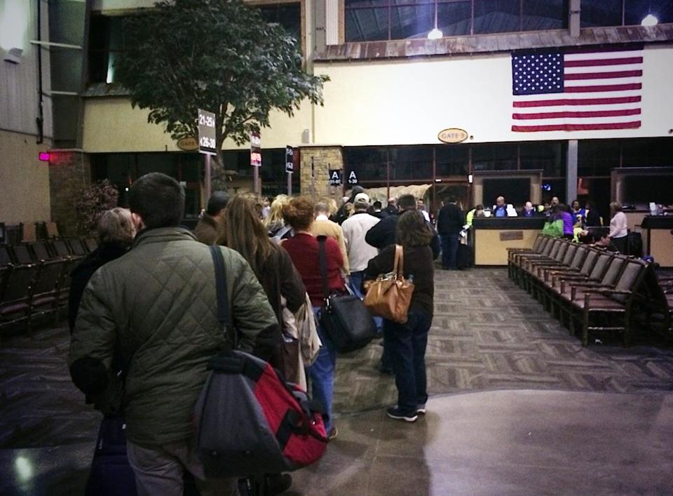 In this Sunday, Jan. 12, 2014 photo provided by Scott Schieffer, passengers line up to board a Southwest Airlines flight from Branson, Mo., to Dallas' Love Field. A Southwest spokesman said the plane was flown in specifically to Branson Airport late Sunday to take the passengers and crew to Dallas after the flight they were on, that was supposed to land at Branson Airport in southwest Missouri, instead landed at a nearby airport that only had about half as much runway. (AP Photo/ Scott Schieffer) MANDATORY CREDIT