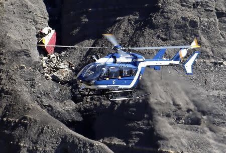 A French Gendarmerie rescue helicopter flies over the debris of the Airbus A320 at the site of the crash, near Seyne-les-Alpes, French Alps March 27, 2015. REUTERS/Emmanuel Foudrot