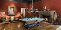 <p>The billiards room features herringbone floors and an intricately designed ceiling and a carved fireplace - both which are from the Hearst Castle in San Simeon. </p>