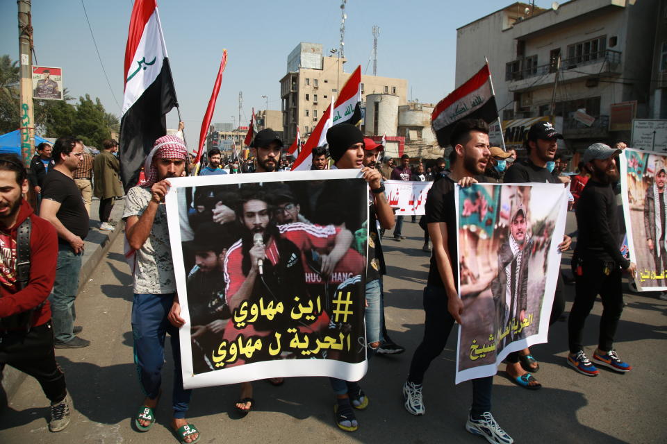 Iraqis hold photos of missing protesters during anti-government protest in Baghdad, Iraq, Sunday, Feb. 23, 2020. There are 25 activists still missing since the protests erupted on Oct. 1, 2019, according to the semi-official Iraqi High Commission for Human Rights. No group has claimed responsibility but activists have blamed the militias. (AP Photo/Khalid Mohammed)