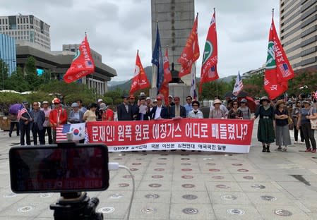 A mobile phone for a live broadcast films members of a conservative civic group taking part in a protest in Seoul