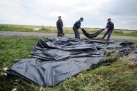 Ukrainian rescue workers collect bodies of victims at the site of the crash of a Malaysia Airlines plane in Grabove, in rebel-held east Ukraine, on July 19, 2014