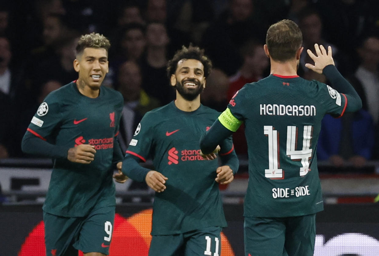 Liverpool's Mohamed Salah (centre) celebrates scoring their first goal against Ajax Amsterdam with teammates Roberto Firmino (left) and Jordan Henderson.
