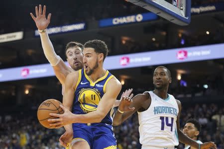 March 31, 2019; Oakland, CA, USA; Golden State Warriors guard Klay Thompson (11) passes the basketball against Charlotte Hornets forward Frank Kaminsky (44) and forward Michael Kidd-Gilchrist (14) during the third quarter at Oracle Arena. Mandatory Credit: Kyle Terada-USA TODAY Sports