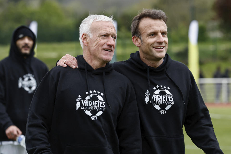 French President Emmanuel Macron, right, walks with Didier Deschamps, former coach of French national football team, to participate in the Varietes Club charity football match to benefit children in hospital, at the Bernard Giroux stadium in Plaisir, outside Paris, Wednesday, April 24, 2024. (Benoit Tessier/Pool via AP)