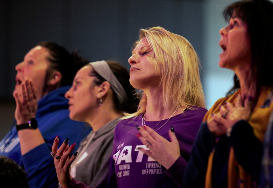 Amie Detzel, 35, who's been in recovery for a year, worships at Vineyard Westside in Cheviot, Ohio, on Jan. 19. She says she started using drugs as a teenager after being sexually abused by a friend of the family. Later, she turned to shooting meth. "I just wanted to try anything, anything that I thought would take me to another level," she says. "I just wanted to escape from what I was feeling."