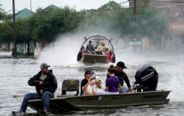 <p>People are rescued from flood waters from Hurricane Harvey on an air boat in Dickinson, Texas, Aug. 27, 2017. (Photo: Rick Wilking/Reuters) </p>