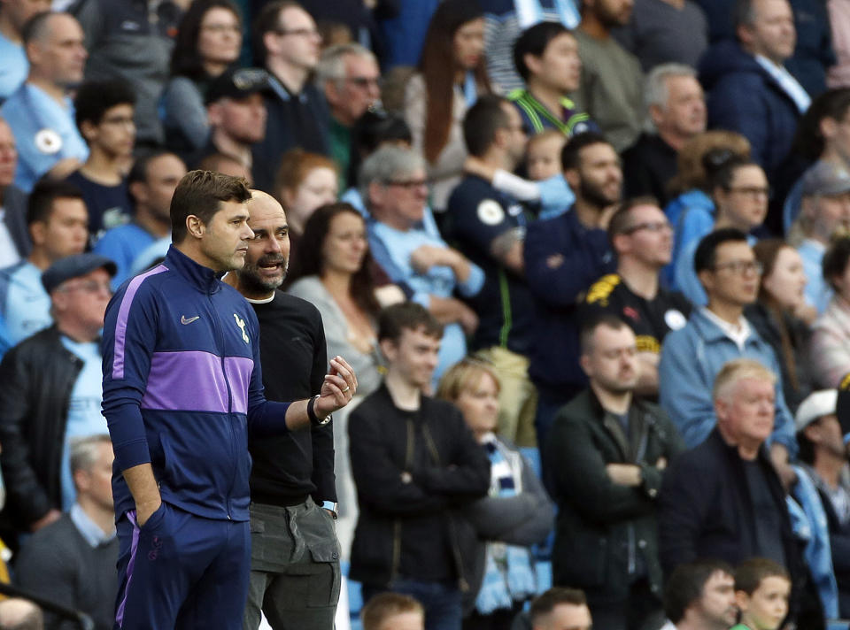 Tottenham's manager Mauricio Pochettino, left, speaks with Manchester City's head coach Pep Guardiola during the English Premier League soccer match between Manchester City and Tottenham Hotspur at Etihad stadium in Manchester, England, Saturday, Aug. 17, 2019. (AP Photo/Rui Vieira)