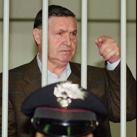 Mafia "boss of bosses" Salvatore "Toto" Riina, is seen behind bars, during a trial in Rome, 1993 - Credit:  AP