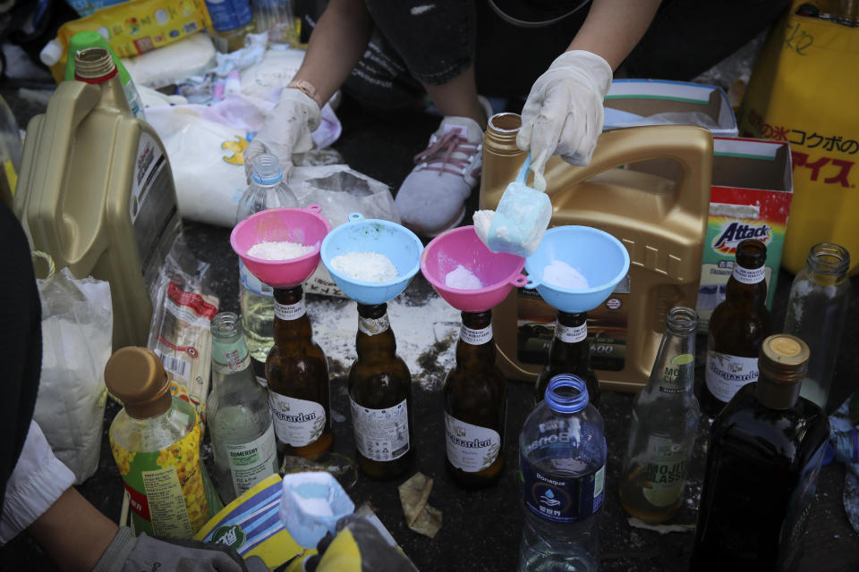 In this Wednesday, Nov. 13, 2019, file photo, students make molotov cocktails at the Chinese University in Hong Kong. Protesters who barricaded themselves inside Hong Kong’s universities have tried to turn the campuses into armed camps, resorting to medieval weapons to stop police from entering the grounds. Their weapons include bows and arrows, catapults and hundreds of gasoline bombs stacked up to ramparts - often built by the students. (AP Photo/Kin Cheung, File)