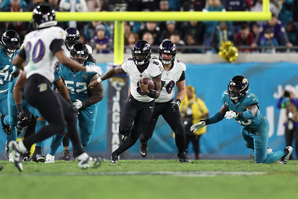 JACKSONVILLE, FLORIDA – DECEMBER 17: Lamar Jackson #8 of the Baltimore Ravens runs with the ball against the Jacksonville Jaguars during the third quarter at EverBank Stadium on December 17, 2023 in Jacksonville, Florida. (Photo by Mike Carlson/Getty Images)