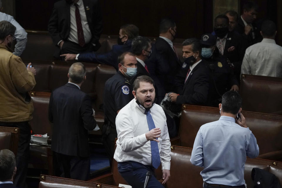Rep. Ruben Gallego, D-Ariz., stands on a chair as lawmakers prepare to evacuate the floor as rioters try to break into the House Chamber at the U.S. Capitol on Wednesday, Jan. 6, 2021, in Washington. (AP Photo/J. Scott Applewhite)
