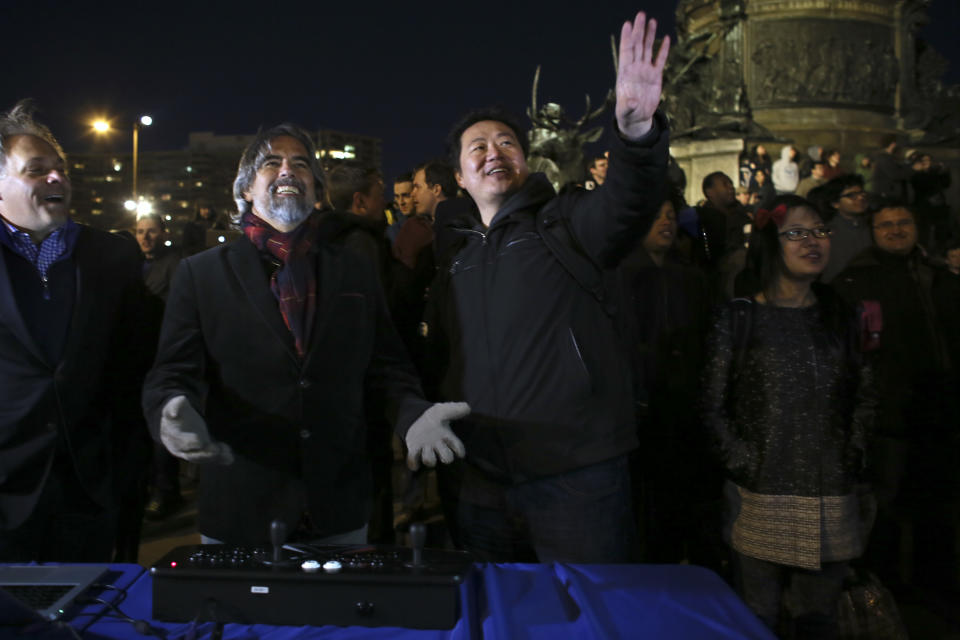 Frank Lee, right, a Drexel University game-design professor, and game designer Henk Rogers, center, play the classic video game Tetris on the 29-story Cira Centre in Philadelphia, Saturday, April 5, 2014, using hundreds of LED lights embedded in its glass facade. The spectacle kicks off a citywide series of events called Philly Tech Week and also celebrates the upcoming 30th anniversary of Tetris. (AP Photo/ Joseph Kaczmarek)