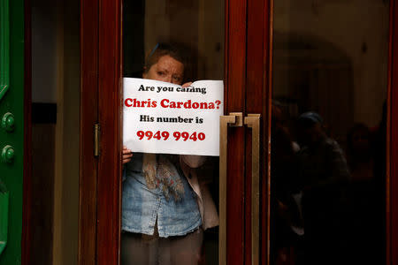 A civil society activist looks out from inside the Valletta police station as a formal complaint was made with the police, demanding questioning of Maltese Economy Minister Chris Cardona, after some of the journalists from the Daphne Project initiative reported him as having met with one of the men accused of the murder of anti-corruption journalist Daphne Caruana Galizia, in Valletta, Malta April 19, 2018. REUTERS/Darrin Zammit Lupi