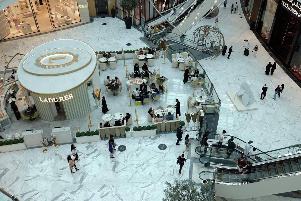 People sit in an open air coffeeshop in the Dubai Mall in Dubai, United Arab Emirates.