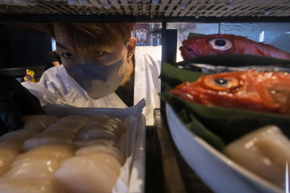 A chef prepares fish at a sashimi restaurant in Hong Kong, Friday, July 14, 2023. As Tokyo plans to discharge treated radioactive wastewater into the sea, Hong Kong’s Japanese restaurants and seafood suppliers are bracing for a slump in business under a potential ban by Hong Kong on aquatic products from 10 Japanese regions. (AP Photo/Louise Delmotte)