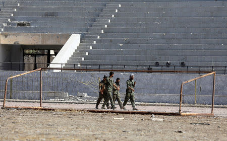 Fighters of Syrian Democratic Forces walk at the stadium in Raqqa, Syria October 18, 2017. REUTERS/Erik De Castro