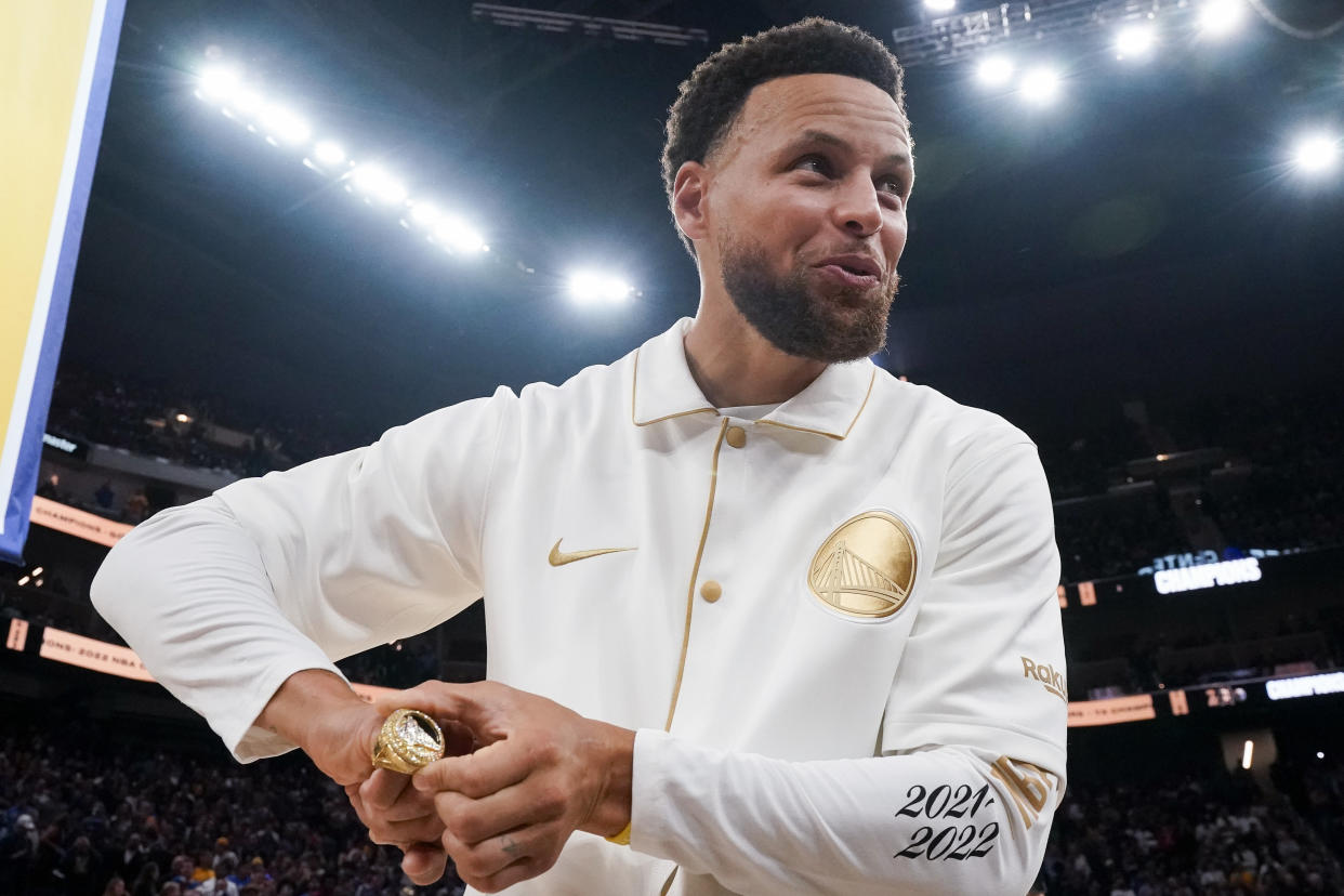 Golden State Warriors guard Stephen Curry reacts after receiving his 2021-2022 NBA championship ring before the team's basketball game against the Los Angeles Lakers in San Francisco, Tuesday, Oct. 18, 2022. (AP Photo/Godofredo A. Vásquez)