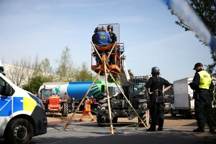 Activists from Just Stop Oil block an entrance to a fuel terminal, during a protest in Grays, Essex on 15 April (REUTERS)